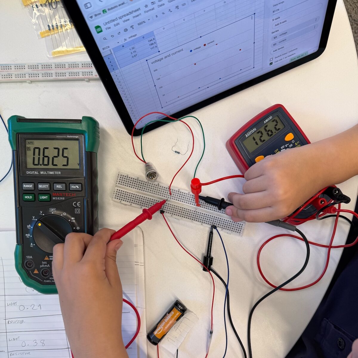 6 year-old student measuring voltage and current in a circuit experiment.